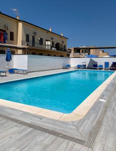 a large blue swimming pool in front of a building at Blue Coral in San Vito lo Capo