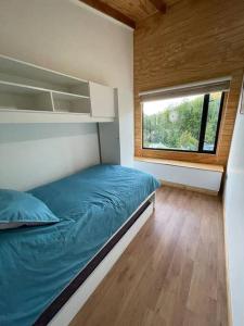 a small bedroom with a bed and a window at Cabaña río Calle Calle in Valdivia