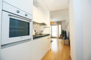 een keuken met een flatscreen-tv aan de muur bij Casa Fenicia - Cosy apartment with free private parking in Málaga +13 foto's