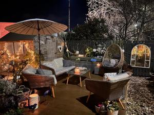 a patio with a couch and chairs and an umbrella at The Coorie Inn @ Portobello, Edinburgh’s Seaside. in Edinburgh