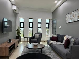 a living room with a couch and a table at Janneya Apartment Salagie in Sukuta