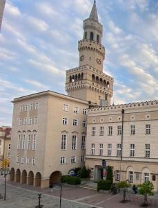 ein Gebäude mit einem Uhrturm darüber in der Unterkunft Red Bike Old Town in Oppeln