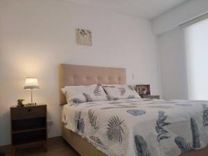 a bedroom with a bed and a night stand with a lamp at LOFT EN LIMA VISTA AL OCEANO - ¡Nuevo! Depa - Magdalena del Mar - in Lima