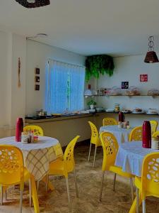 a dining room with yellow tables and yellow chairs at Pousada Lá na Praia Maragogi in Maragogi