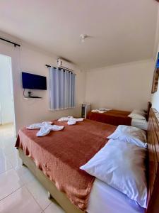 1 dormitorio con 2 camas y toallas. en Pousada Lá na Praia Maragogi en Maragogi
