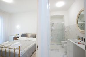 baño blanco con cama y ducha en BB Elite Berchet, en Padua