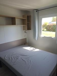 um pequeno quarto com uma cama e uma janela em Le panorama em Guérande