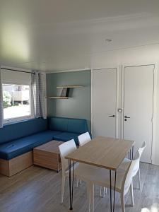 une salle à manger avec un canapé bleu et une table dans l'établissement Le panorama, à Guérande