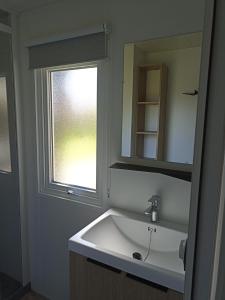 baño con lavabo blanco y ventana en Le panorama en Guérande