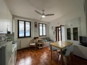 布倫佐內的住宿－Appartamento alla Playa，厨房以及带桌子和吊扇的用餐室。