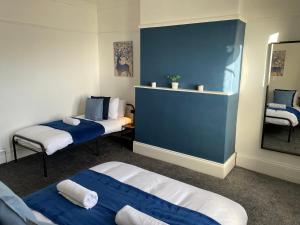 Habitación con 2 camas y espejo. en Overhill - Spacious 2 bed ground floor flat close to Newcastle, en Gateshead