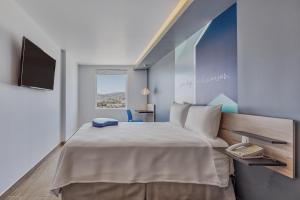 a bedroom with a large bed and a flat screen tv at One Mazatlán in Mazatlán