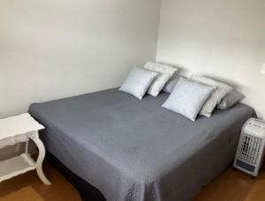 a bed with three pillows on it in a room at Triplex ideal para grupos. Acomoda mais de 20. in Curitiba