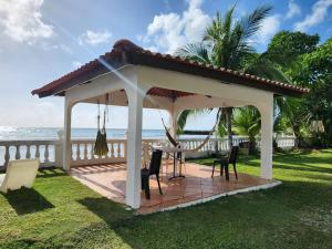 gazebo con tavolo e sedie sull'erba di Casa de Campo, frente a la playa Skybluebyguanche a Colón