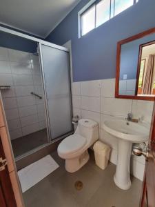 a bathroom with a toilet and a sink and a shower at Pampa Bella Lodge in La Merced