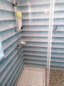 a shower in a bathroom with blue tiles at Gaillarde in Brive-la-Gaillarde