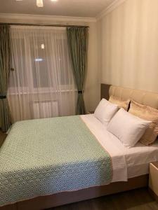 a bedroom with a large bed and a window at Nice apartment in Pʼonichala