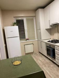 Nice apartment في Pʼonichala: مطبخ مع طاولة وثلاجة بيضاء