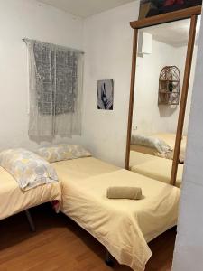une chambre avec deux lits et un miroir dans l'établissement Malvarrosa habitación cómoda y sencilla cerca de la playa, à Valence