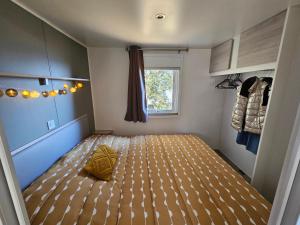 リュミオにあるMobilhomme LECCI 3 CHAMBRES AVEC VUE MER EXCEPTIONNELLEの小さな部屋で、ベッドルームにベッド1台が備わります。