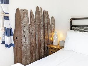 ein Schlafzimmer mit einem Kopfteil aus Holz neben einem Bett in der Unterkunft Seaside in Selsey