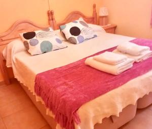 a bedroom with a bed with towels on it at Chalet en Valle del Tietar in Lanzahita