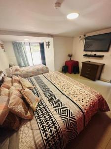 1 dormitorio con 2 camas y TV de pantalla plana en Vieille Mansion, en Quito