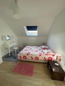 a bedroom with a bed with a red comforter and a mirror at Super maison entre paris et Disney in Chelles