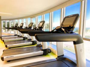 a row of treadmills in a gym with windows at HOTEL NACIONAL - Não tem café da manhã incluído in Rio de Janeiro