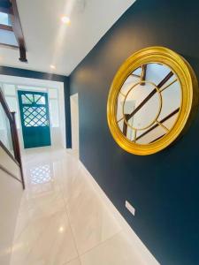 a large yellow clock on a blue wall in a room at Farmhouse in Virginia County Cavan in Cavan