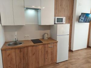a kitchen with a sink and a white refrigerator at Apartment Two-room "Family Estate" in Kamianets-Podilskyi