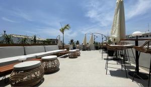 un patio con sillas, mesas y un sofá en Serene La Playa Boracay, en Boracay