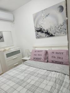 a bedroom with a bed with two pink pillows at city holiday in Rishon LeẔiyyon