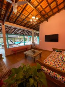 a living room with a couch and a tv at Pousada Maria Felipa Ilhabela in Ilhabela
