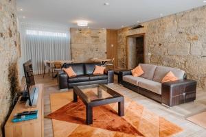 een woonkamer met een leren bank en een tafel bij Sete Azenhas in Esposende