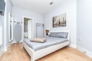 ein weißes Schlafzimmer mit einem Bett in einem Zimmer in der Unterkunft Modern Apartment in East London in London