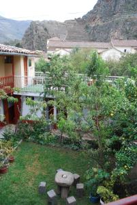 un jardin en face d'une maison avec un arbre dans l'établissement Hospedaje La Ñusta, à Ollantaytambo