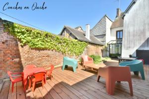 Conches-en-Ouche的住宿－Hyper-centre de Conches-en-Ouche.，一个带桌椅的庭院和砖墙