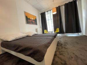 ベルリンにあるBerlinhome Apartment Köpenickのベッドルーム1室(黒いカーテン付きの大型ベッド1台付)
