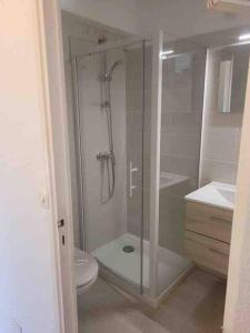 een badkamer met een glazen douche en een toilet bij Grand Studio véranda et terrasse in Carqueiranne