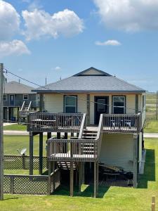 una casa con due sedie a sdraio e un edificio di Sunshine DayDream by SurfBreakLLC a Surfside Beach