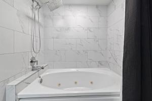 a white bathroom with a tub and a shower at Ascot Suites Morro Bay in Morro Bay +28 photos