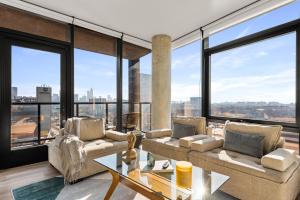 a living room filled with furniture and large windows at Designer Apt near Union Park - Cloud9-1125 in Chicago