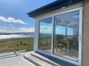 a sliding glass door on a house with a table at Cruit Island Holiday Rent in Cruit