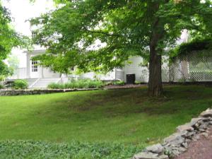 una casa blanca con un árbol en el patio en B&B on seven acres with private bed & bath, en Clinton Corners