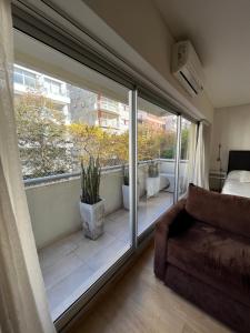 sala de estar con una puerta corredera de cristal que da a un balcón en Departamento de Lujo Belgrano 2 A en Buenos Aires