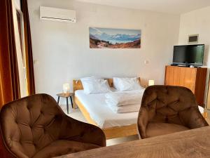 pokój hotelowy z łóżkiem i dwoma krzesłami w obiekcie Rooms & Apartment Hegic w mieście Zadar