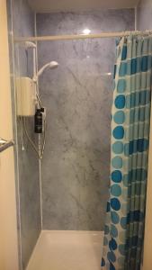 a bathroom with a shower with a shower curtain at Royal Mile Apartment, 1 minute from the castle. in Edinburgh