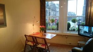 a room with a table and chairs and a window at Royal Mile Apartment, 1 minute from the castle. in Edinburgh