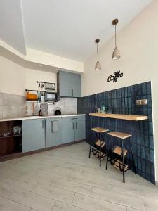 uma cozinha com armários azuis e dois bancos de bar em Апартаменти Underground&SPA em Lviv